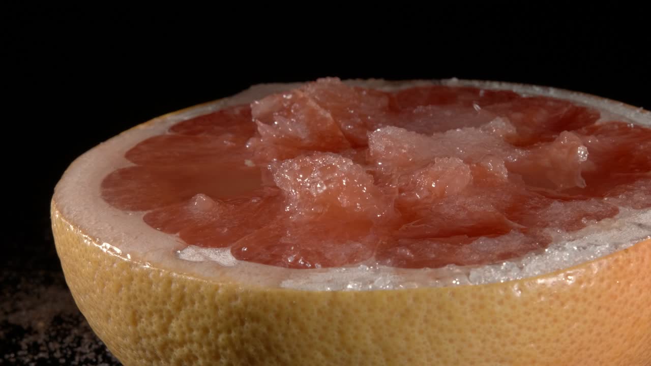 그레이프프루트와 설탕, 그 자체의 주스 클로즈업, 검은 배경.