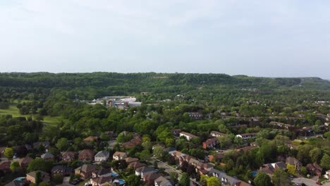 drone volando hacia el barrio de hamilton ubicado al pie de colinas distantes