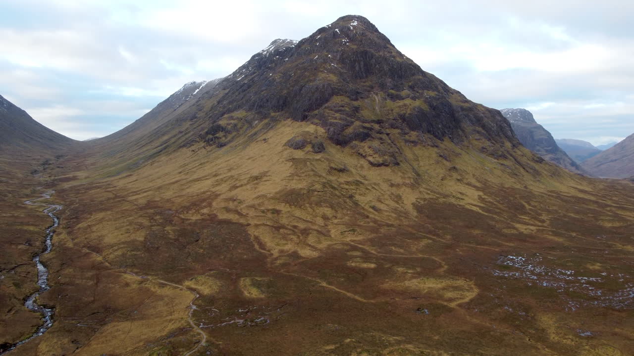 Impresionante toma aérea de movimiento lento de las colinas y montañas en Glencoe, Escocia, Gran Bretaña.