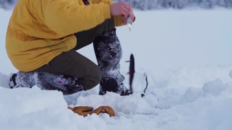 Man-Catch-Fish-On-The-Frozen-River-In-Winter-In-Indre-Fosen,-Norway---closeup