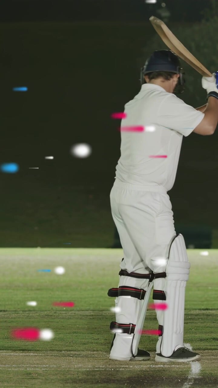 Video verticale: Battitore che oscilla la mazza sul lancio del lanciatore per colpire la palla, scie RGB da cricket dietro il battitore.