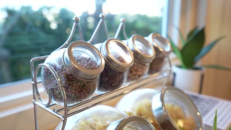 cute and stylish jar filled with spice on rack in kitchen, close up