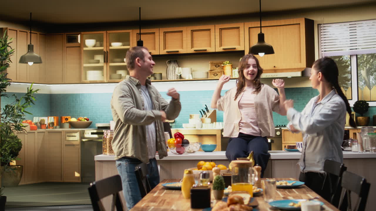 Family in the kitchen dancing and singing during breakfast meal
