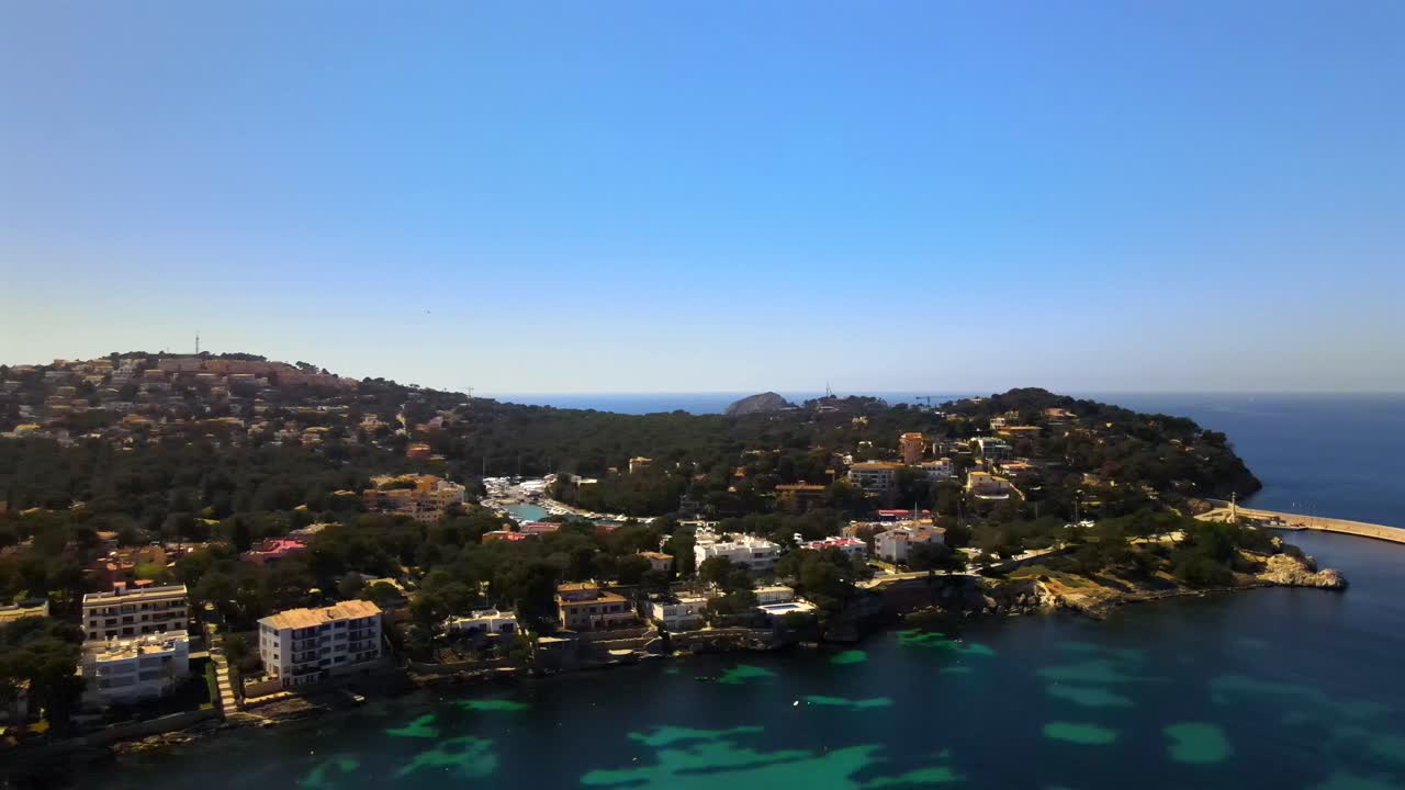 Capture the beauty of Santa Ponsa in Mallorca with stunning coastal views, vibrant architecture, and crystal-clear waters under a bright blue sky. Ideal for travel enthusiasts.
