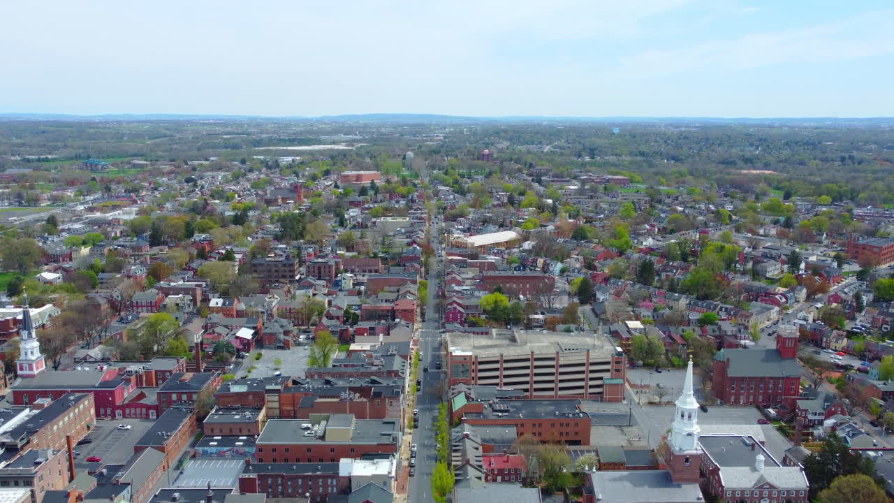 A drone pans up from the steeples and rooftops of Lancaster City to reveal the wide-reaching beauty of Lancaster County, Pennsylvania—blending urban architecture with the surrounding rural sprawl.