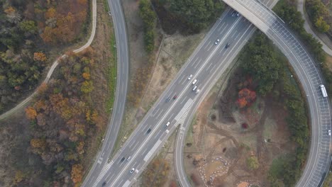 los coches conducen a lo largo de un cruce de carreteras en forma de bucle vista superior.