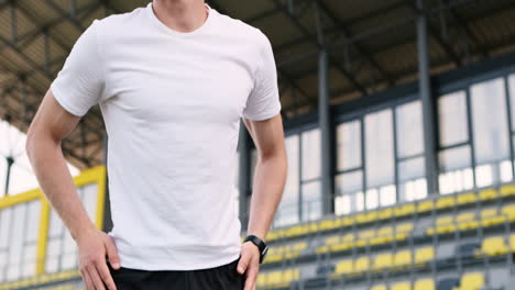 zmęczony sportowiec fitness odpoczywa z rękami na kolanach i sprawdza smartwatch po treningu