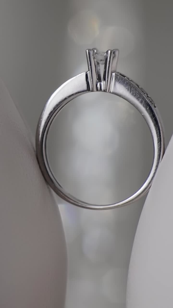 婚戒指在女人的白色鞋子上