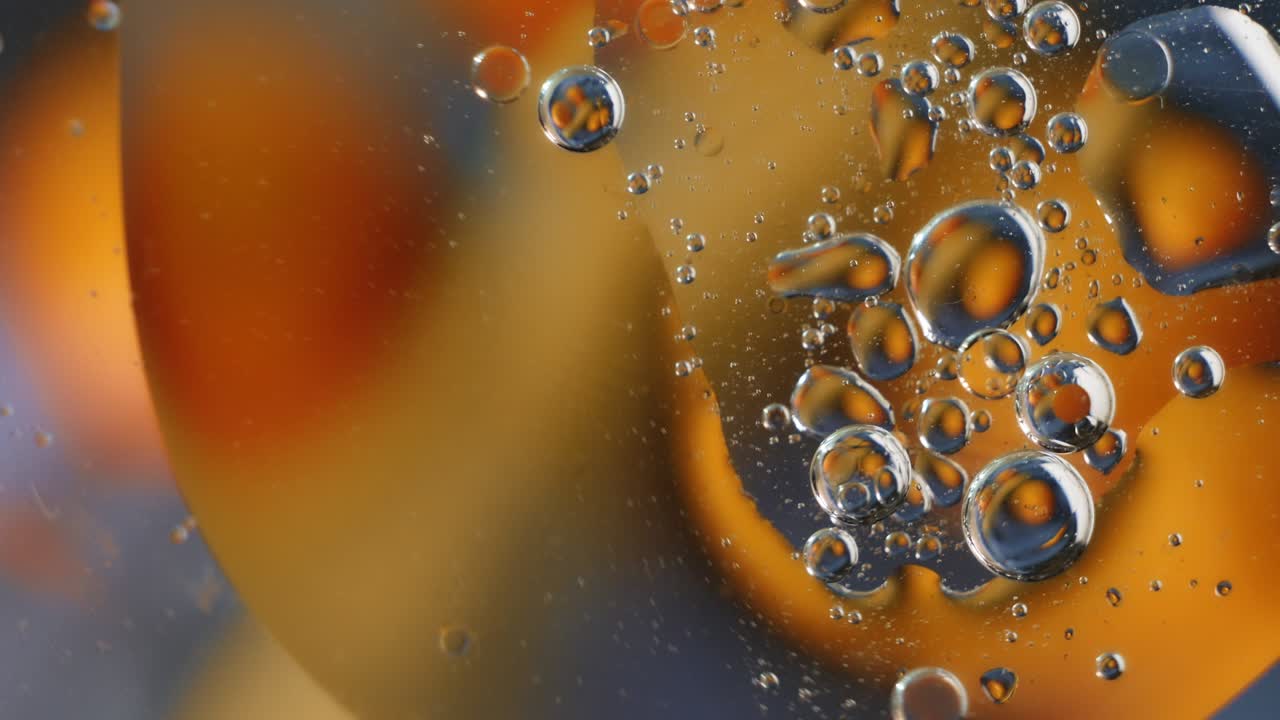 물 위에 떠있는 노란색 기름 방울. 추상적인 거품 배경