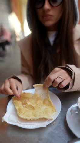 woman eating a pastry in a cafe
