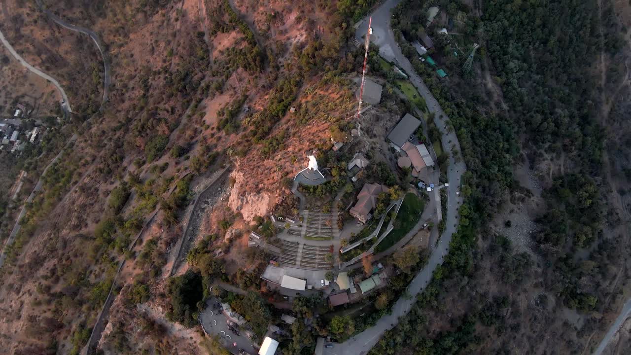 antena de arriba hacia abajo girando sobre el santuario de la inmaculada concepción y la estatua en la cumbre del cerro san cristobal a la hora dorada, santiago, chile