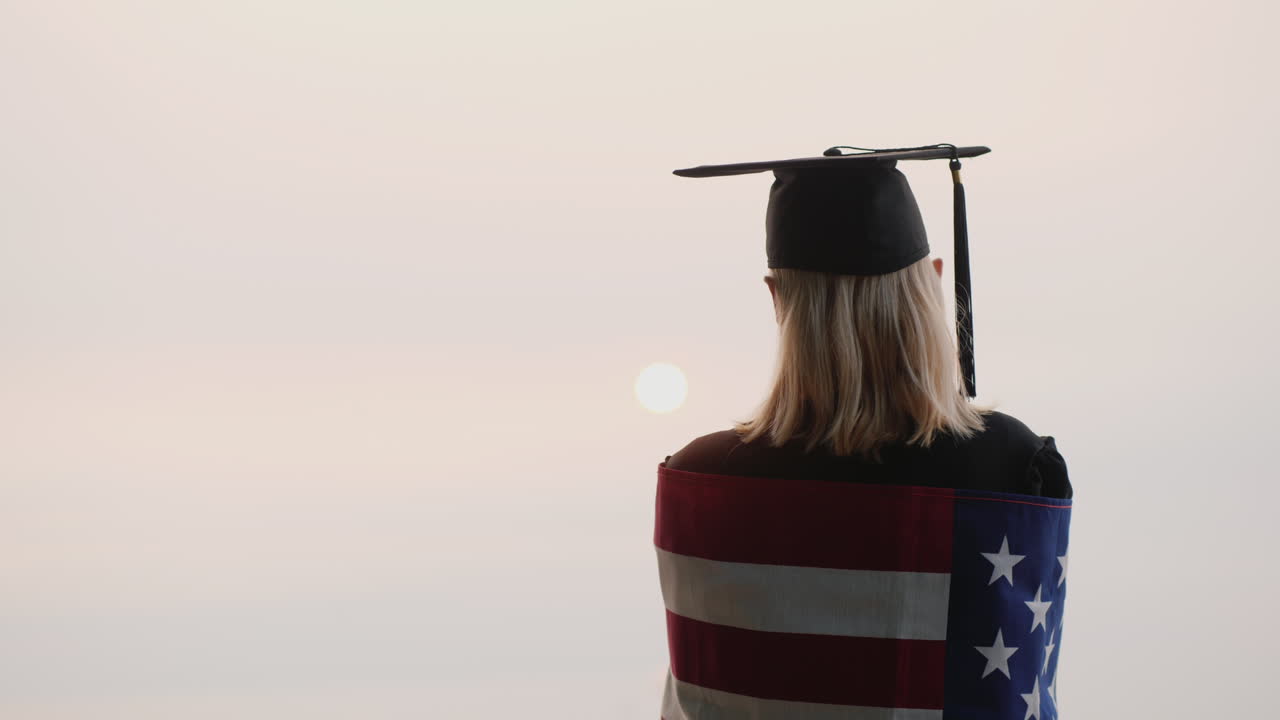 vista trasera de un graduado con la bandera de estados unidos estudiar en nosotros