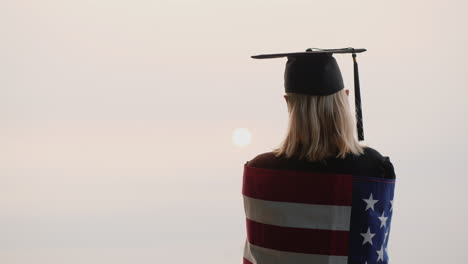 vista trasera de un graduado con la bandera de estados unidos estudiar en nosotros