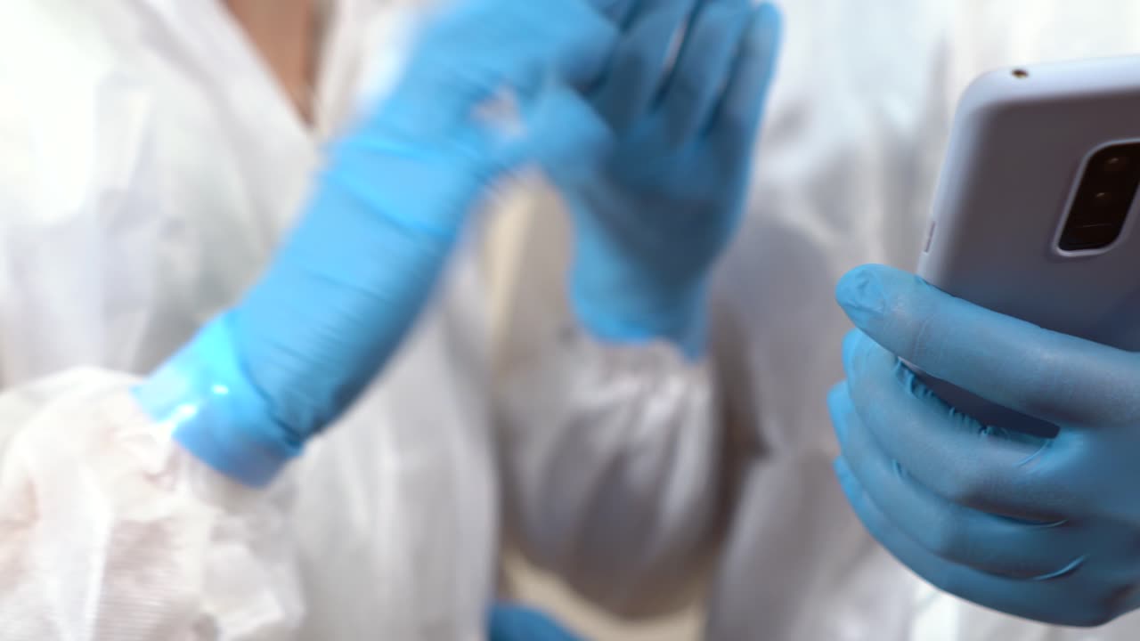 hands of doctors while they talk checking things on the mobile phone