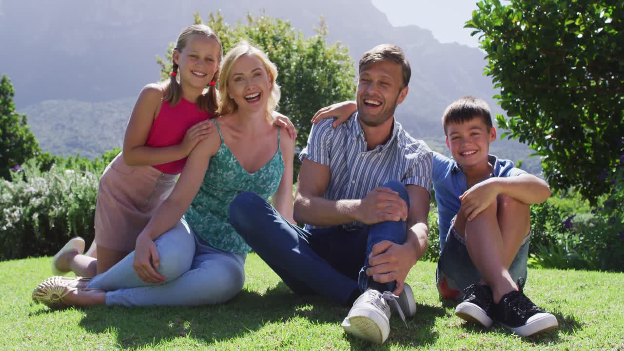 밝은  ⁇ 빛 날 에 정원 에 앉아 함께 미소 짓는 백인 가족 의 초상화