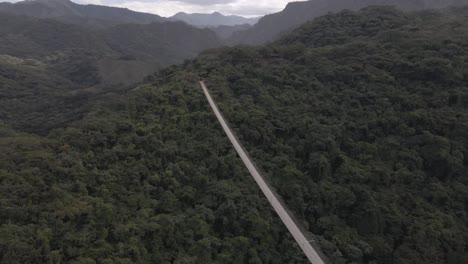 Engaging-fly-by-drone-shot-of-the-Jorullo-Bridge-nestled-in-Sierra-Madre-mountains-near-Puerto-Vallarta,-Mexico-on-a-cloudy-day