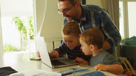 padre y hermanos usando portátil en la sala de estar 4k