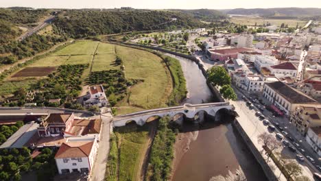 aerial dolly shot over the historic town of silves in portugal, showing the river and bridge on a bright sunny day