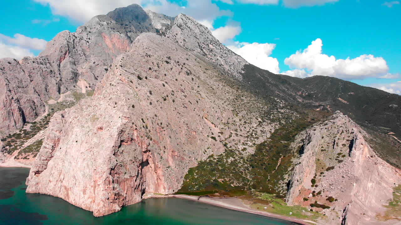 Beautiful Moutain Landscape Surrounded By Turquoise Blue Water With A Bright Blue Sky On The Background In Greece. - aerial drone shot