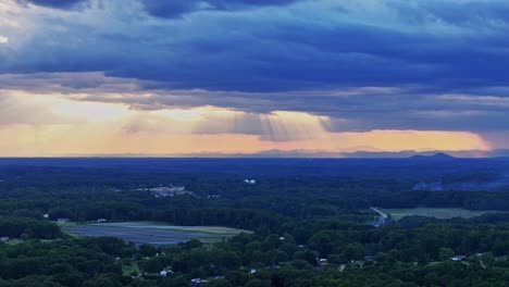 un vuelo de drones sobre el condado de greenville en carolina del sur que muestra un paisaje de árboles, montañas y nubes de tormenta.