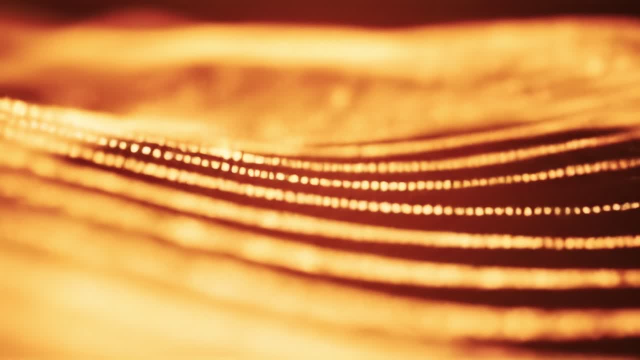 Colorful waves of gold ripple and shimmer, creating a captivating display of light and energy. This dynamic movement showcases the beauty of abstract design.