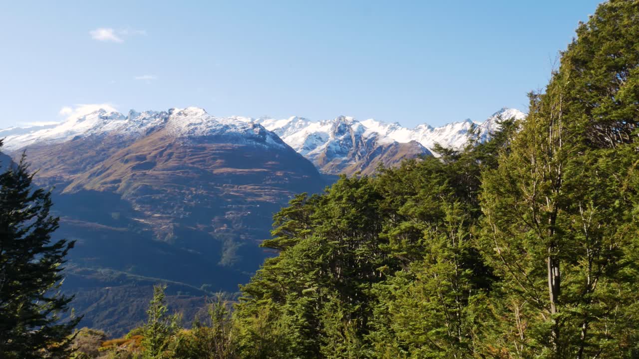 foto panorámica de enormes montañas con un pico blanco nevado en la cima durante un día soleado en una caminata en el parque nacional con vegetación de nueva zelanda