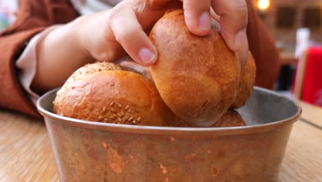 mujer tomando un pan de un cuenco