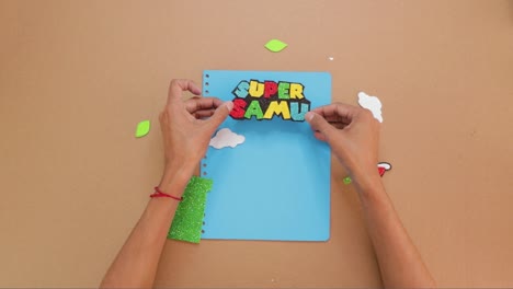 gluing paper art letters to custom made notebook cover, video game themed kids notebook