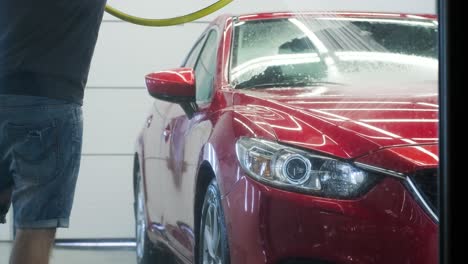 lavado de automóviles limpieza con espuma y agua a alta presión. coche rojo