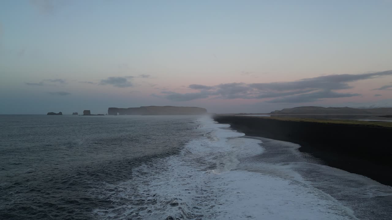 amanecer mirando hacia los acantilados en reynisfjara en islandia, desde el aire