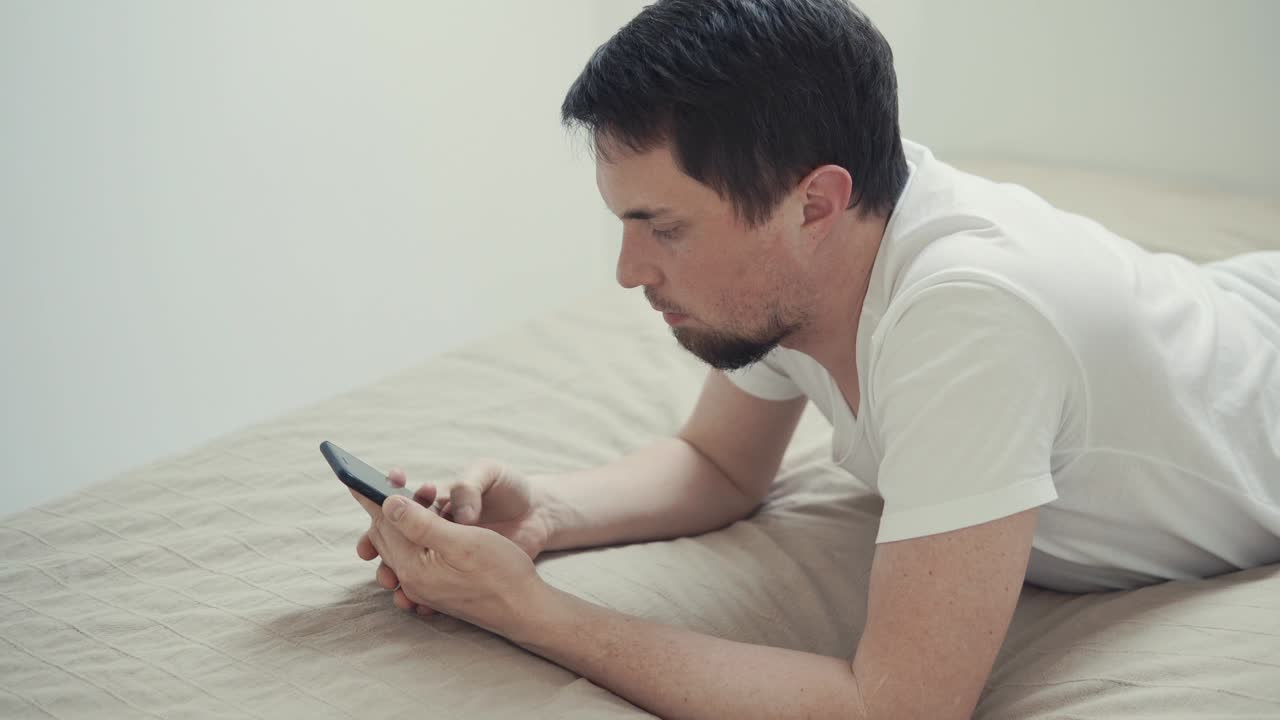 젊은 남자는 인터넷을 통해 소셜 네트워크에서 친구들과 전화로 소통합니다.