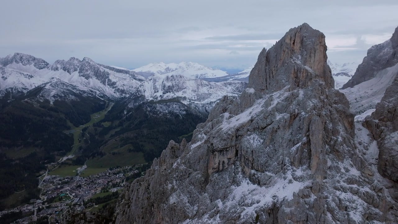 Images aériennes tournant autour des sommets rocheux des montagnes autour de La Rosetta dans les Dolomites en Italie, avec la ville de San Martino di Castrozza dans la vallée en contrebas.
