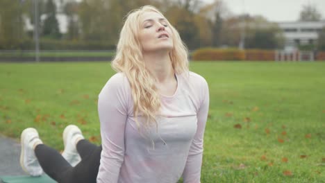 mujer realiza bhujangasana cobra postura de yoga en el parque