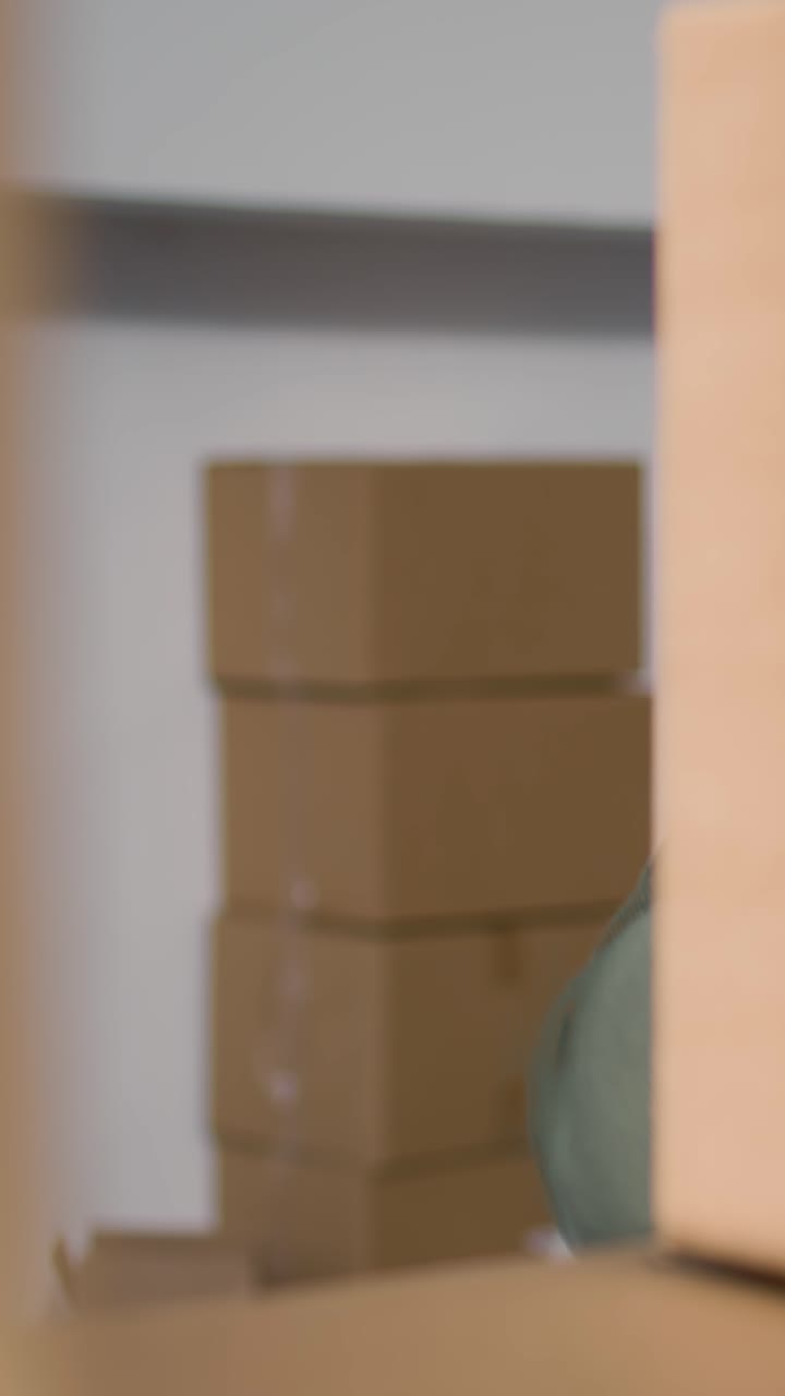 Vertical video Employee in warehouse handling boxes