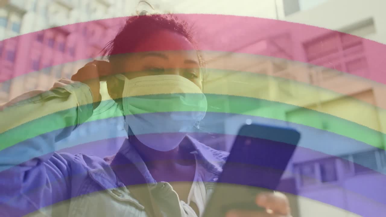 arco iris contra una mujer que usa una máscara facial usando un teléfono inteligente