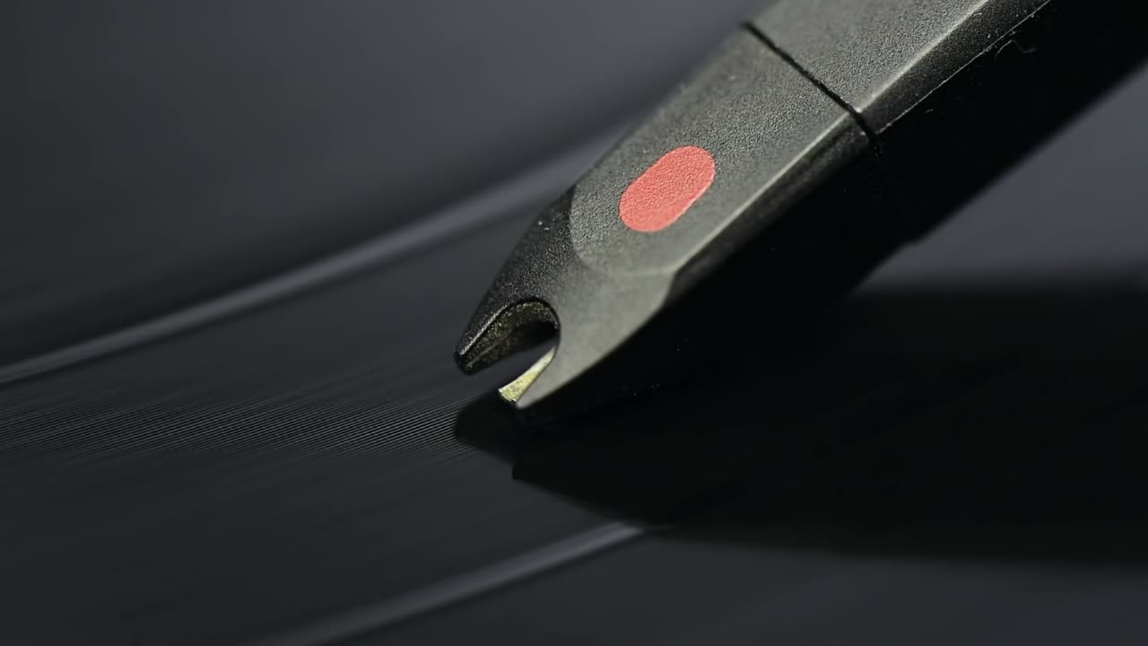 Macro shot of vinyl player needle over playing record