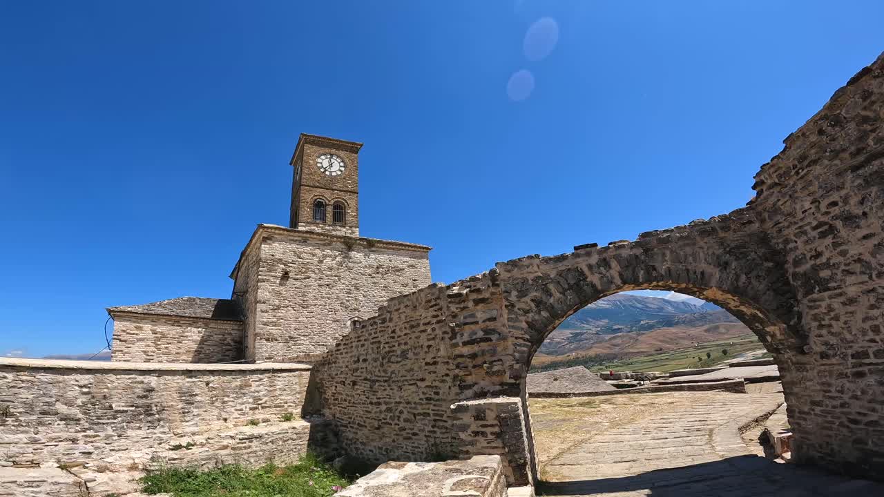 Architettura con torre dell'orologio e arco in pietra
