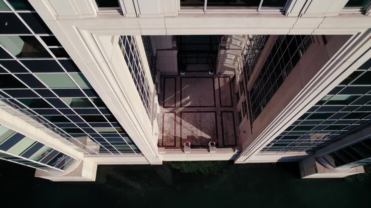 Toma aérea descendente con inclinación hacia arriba mostrando un impresionante edificio abstracto de cristal.