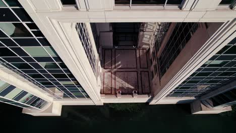 toma aérea descendente con inclinación hacia arriba que muestra un impresionante edificio de vidrio abstracto