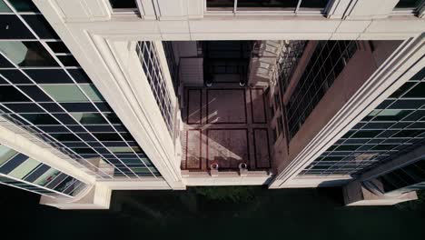 descending aerial shot with tilt up showing a stunning abstract glass building