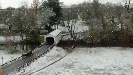 Amish-horse-and-buggy-exit-white-covered-bridge-during-winter-snow-storm