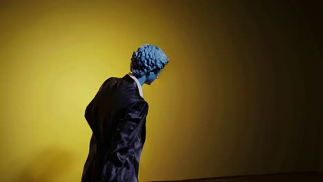 maniquí azul en traje de negocios sobre fondo amarillo