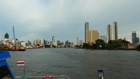 pov filmado en un barco de crucero en chao phraya con edificios de gran altura de bangkok en el fondo