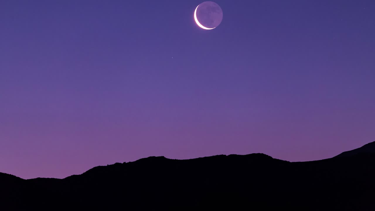 impresionante salida de la luna sobre la montaña en el crepúsculo de la noche oscura y el cielo nocturno rosado antes de que salga el sol en irán