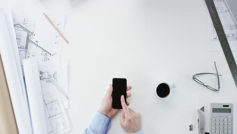 vista superior arquitecto diseñando casa conectada usando pantalla táctil de teléfono inteligente manos trabajando en el escritorio desde arriba - dragón épico rojo
