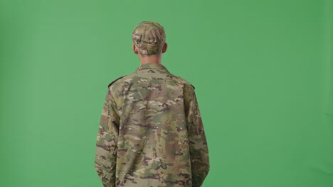 back view of asian man soldier looking around while standing in the green screen background studio