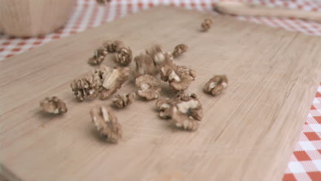 walnut kernels falling in super slow motion on a wood board