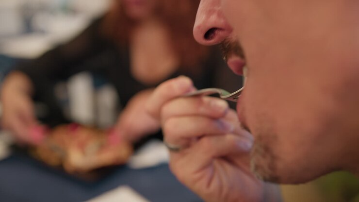 Man Eating With The Fork A Clam During Lunch At Restaurant