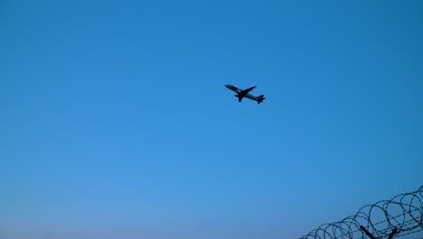 aircraft during flight leaving warsaw chopin airport with barbed wire fence in the ground
