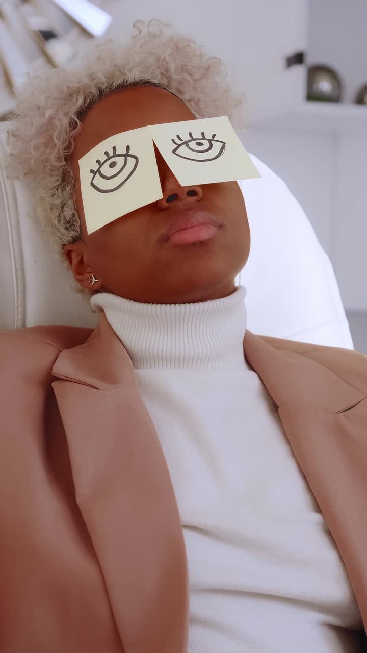 Young woman leaned back in office sticky notes with closed eyes on them